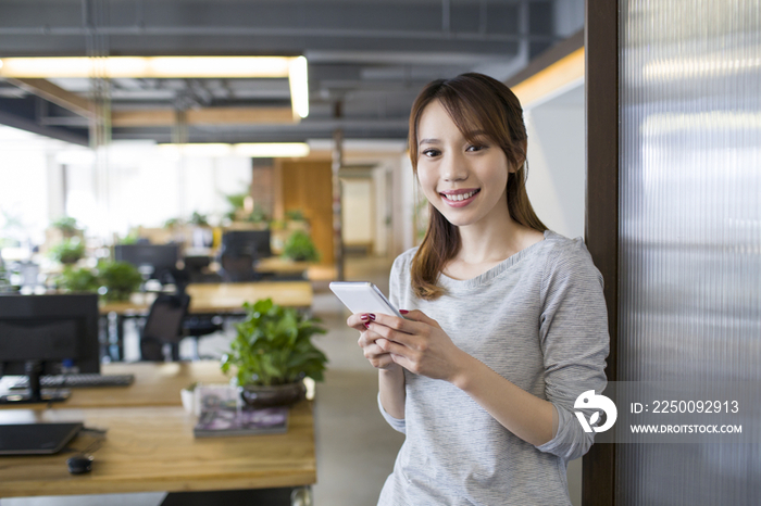 年轻女子在办公室使用手机