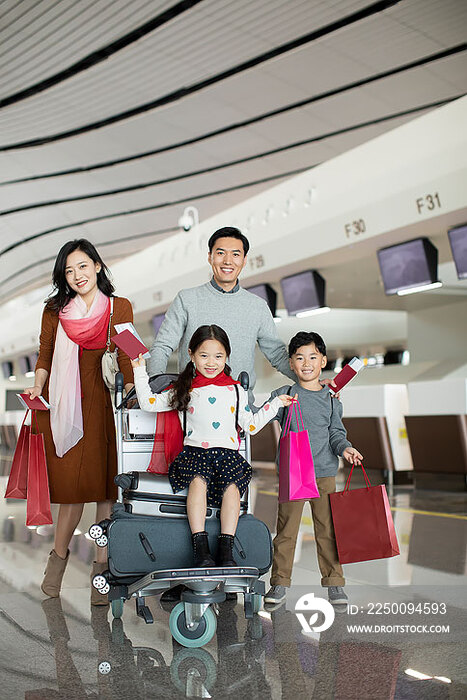 快乐的年轻家庭在机场准备出发去旅行