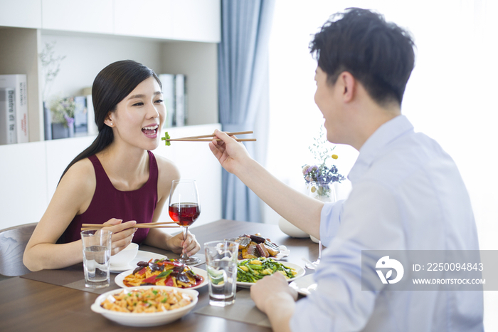 年轻夫妇在家喝红酒吃午餐