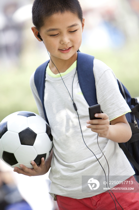小男孩拿着足球听MP3