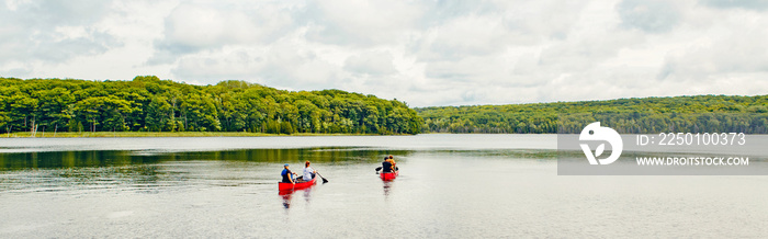 加拿大森林公园自然与家人朋友一起乘坐红色皮划艇独木舟在水中。美丽的l