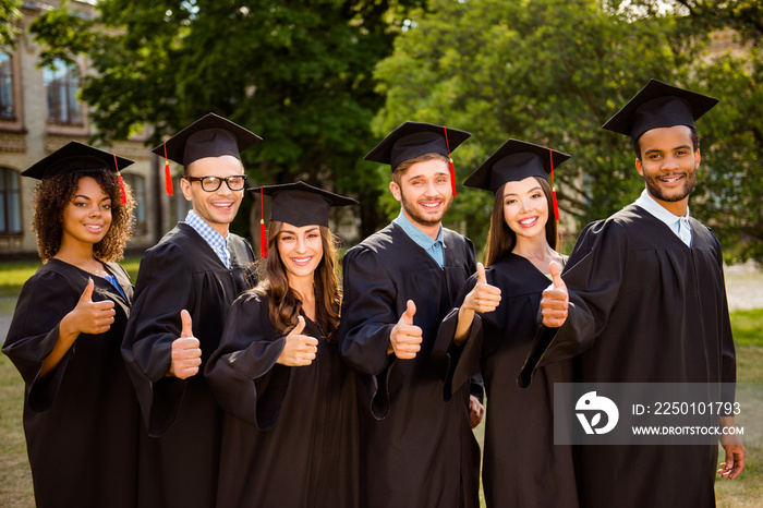 六位成功的、快乐的、多民族的、有吸引力的、身穿黑色长袍和帽子的年轻毕业生完成了他们的学业