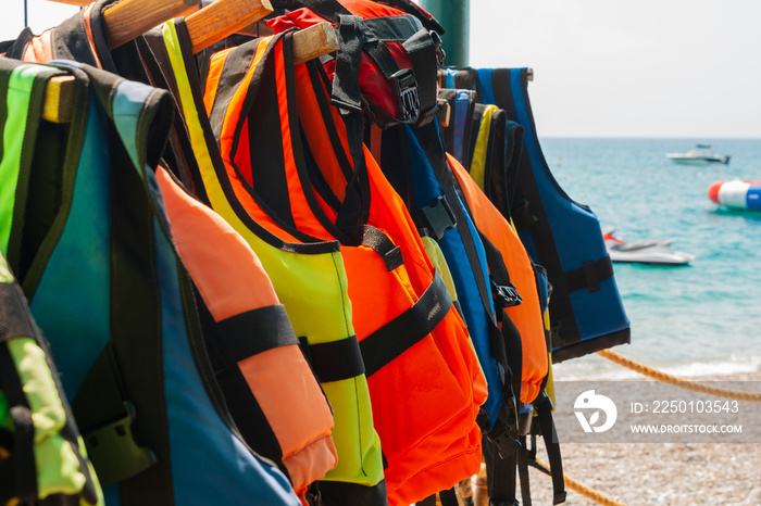 救生衣或救生背心挂在划船站墙上对抗海浪的特写组