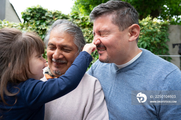 Smiling senior man with son and granddaughter outdoors