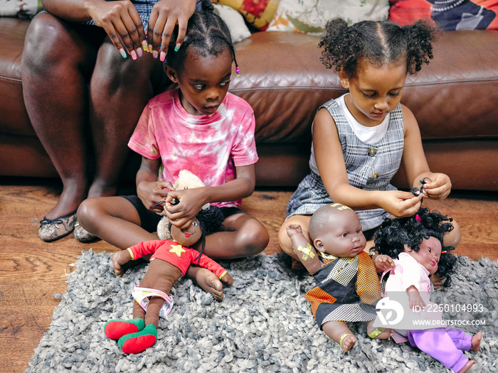 Girls sitting on floor and playing with dolls