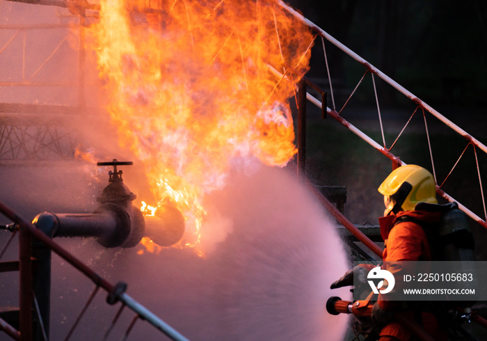 消防员使用水雾喷射石油钻机工厂爆炸产生的火焰