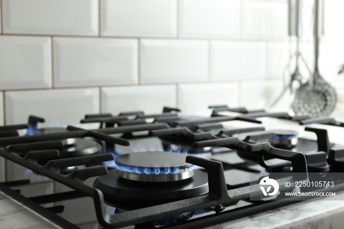 家用厨房炉灶顶部蓝色火焰的特写镜头。丙烷燃烧的燃气灶