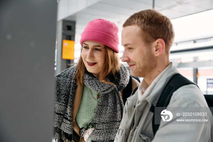 Two people getting a train ticket