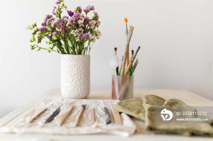 Set of dirty art and craft sculpting tools on wooden table in pottery workshop.Handmade create Conce