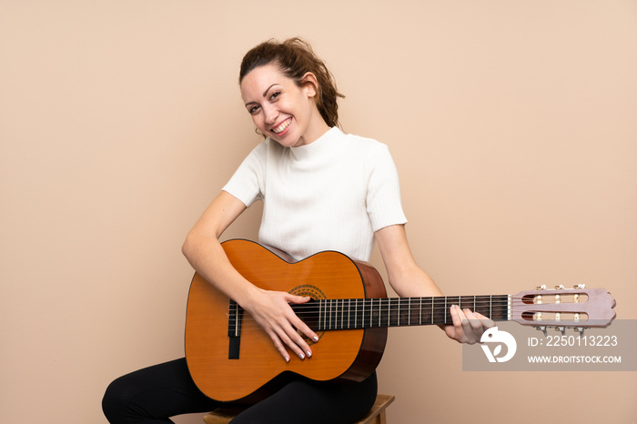 Young woman with guitar over isolated background