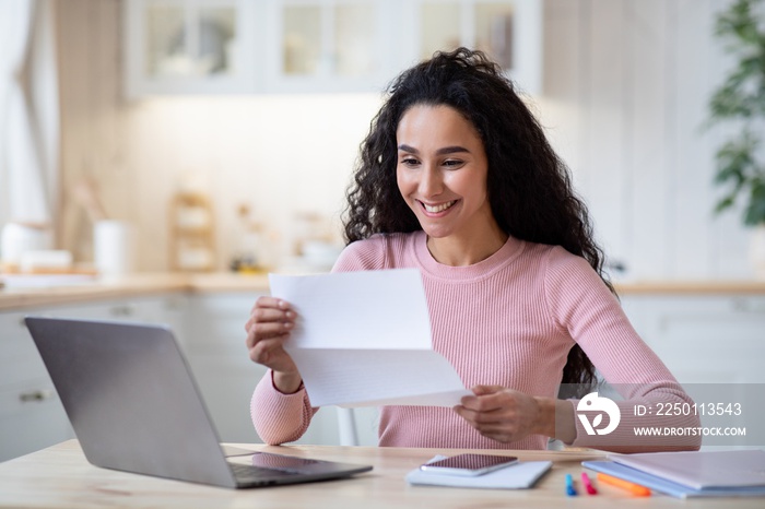 Portrait Of Excited Happy Woman Reading Letter In Kitchen