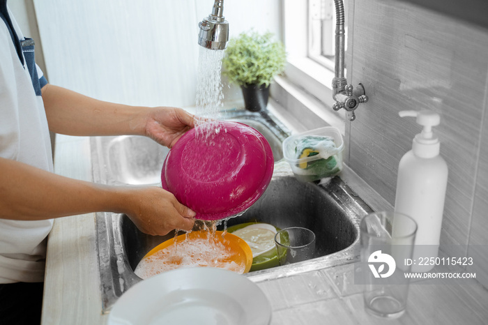 close up of hand rinse the plate in the kitchen sink