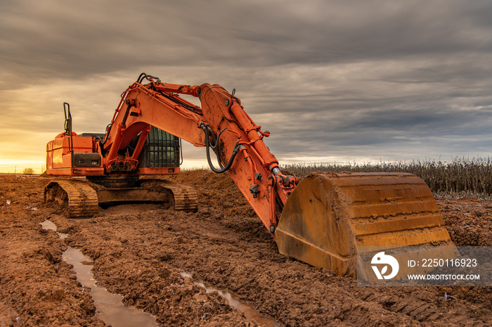 Excavator doing work on a wet and muddy winter day