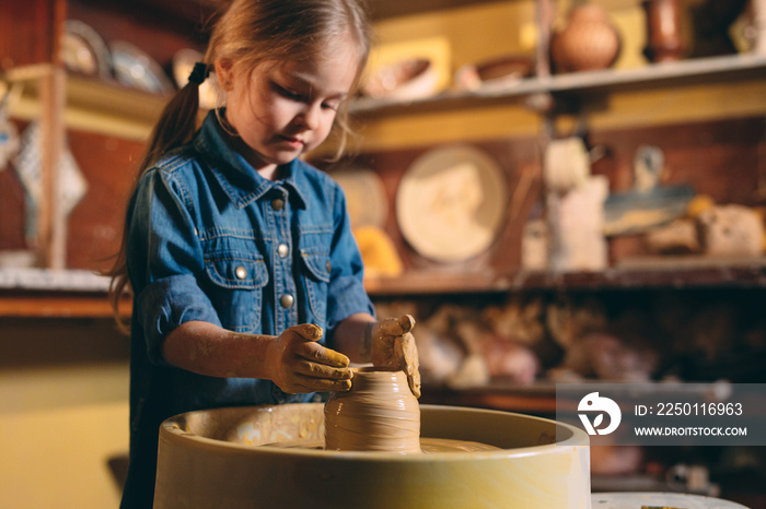陶器作坊。一个小女孩用粘土做花瓶。粘土建模