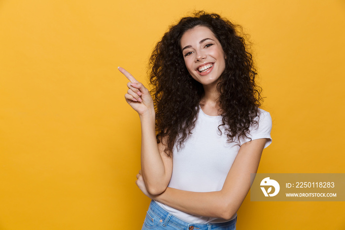 Young cute woman posing isolated over yellow background pointing.