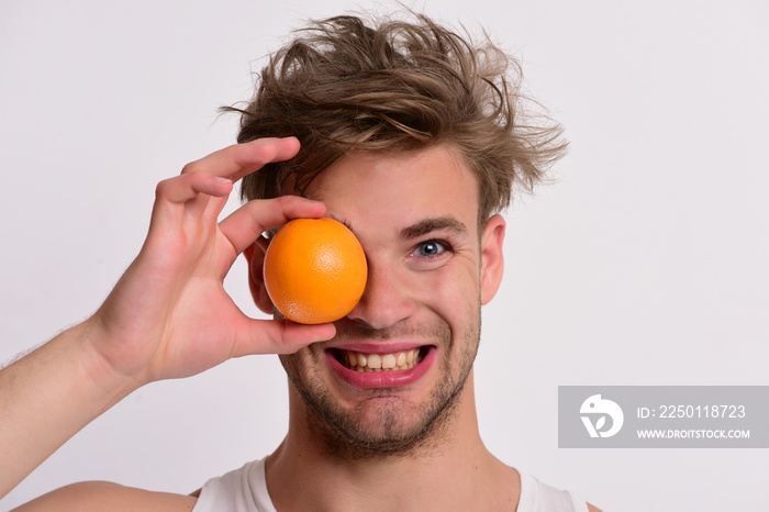 Man with orange covering one eye in his hand