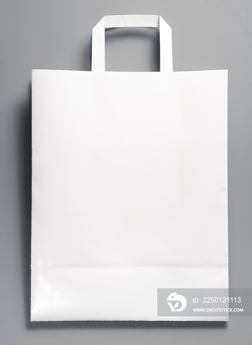 White paper bag with handles on gray background