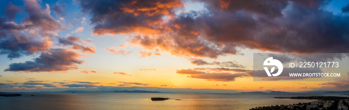 Weites Aerial Panorama eines bewölkten Sonnenunterganges über dem Meer mit von der Sonne rot angestr