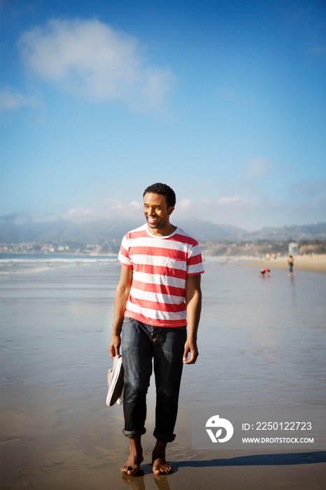 Young man walking on beach