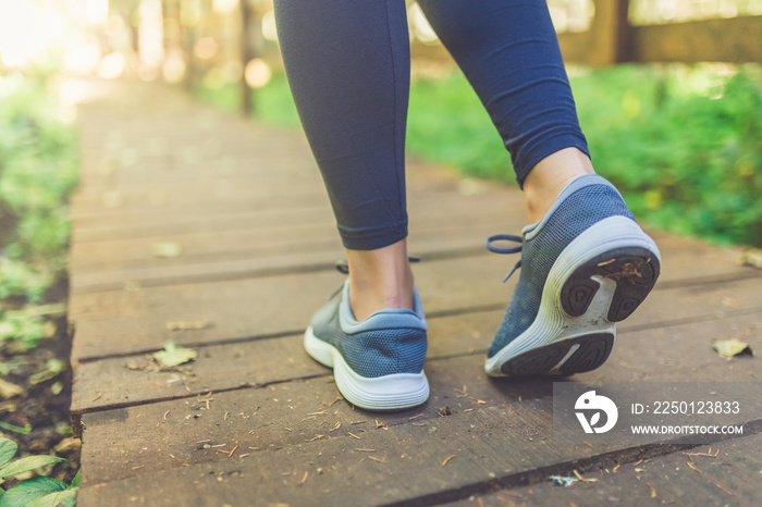 女性跑步者在大自然中行走。特写鞋子。健康的生活方式健身理念。
