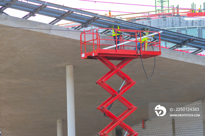 Bauarbeiter, Architekten und Ingenieure begutachten einen Rohbau aus Beton und Stahl mit einer roten