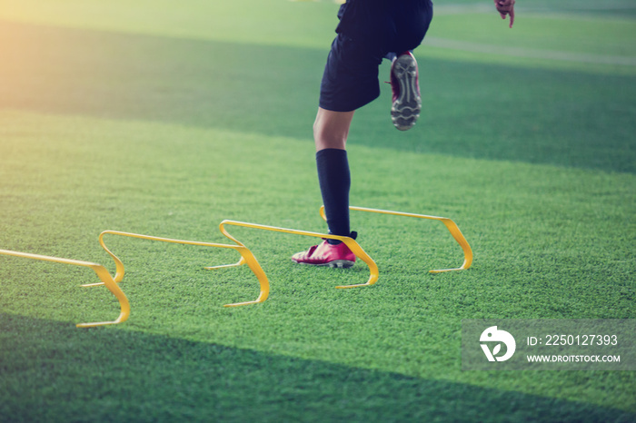 儿童足球运动员在标志栏和黄色栏之间慢跑和跳跃。足球训练。
