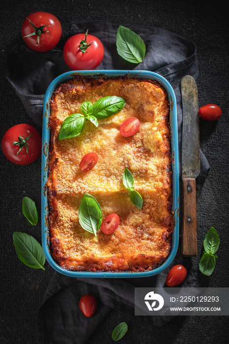 Hot lasagna with bechamel sauce, tomatoes and herbs