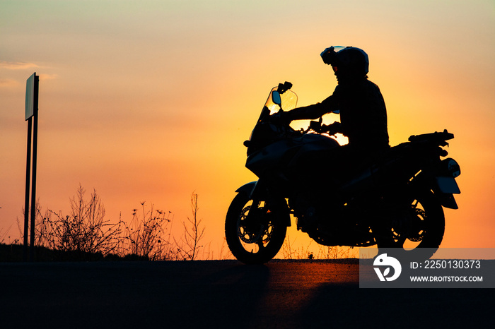 man on his motorbike riding into sunset