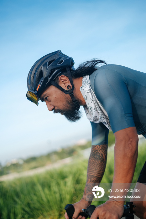 A bearded cyclist riding his gravel bike.