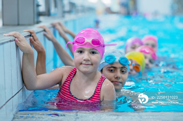 happy kids at the swimming pool. young and successful swimmers pose.