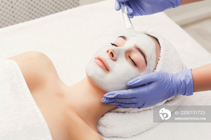 Woman gets face mask by beautician at spa