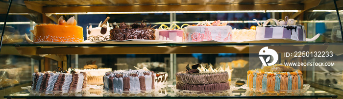 Pastry shop glass display with selection of cream or fruit cake.