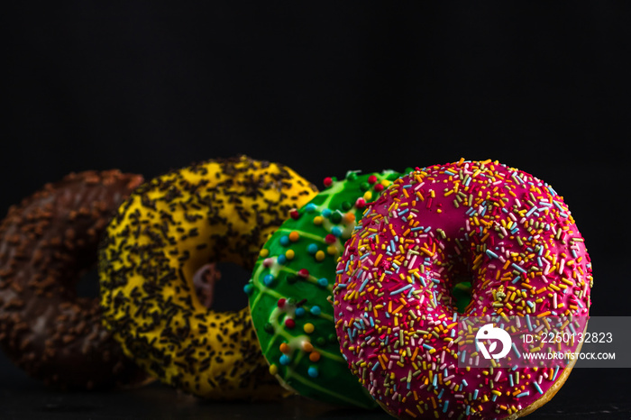 Glazed donuts with sprinkles isolated. Close up of colorful donuts.