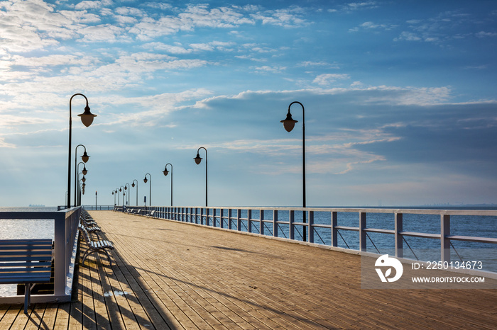 Wooden pier with benches and lanterns in the morning. Gdynia-Orlowo. Poland.