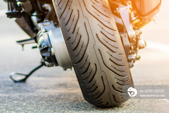运动摩托车的后轮在路上。摩托车停在街上。自由和旅行的概念。