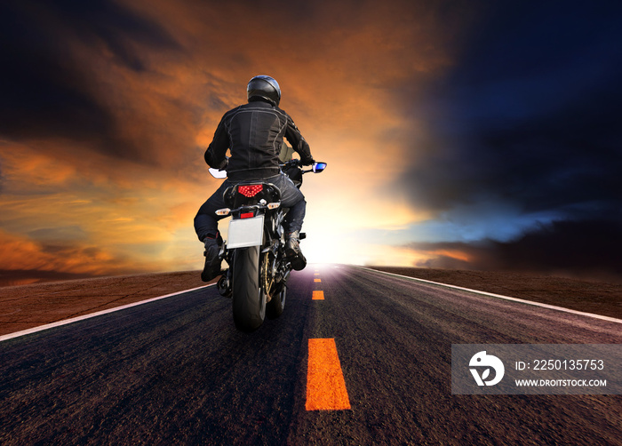 man riding motorcycle on highway against beautiful  sun set sky