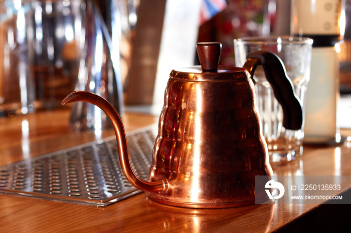 咖啡馆桌子上有一个细长壶嘴的铜壶。茶和咖啡专用茶壶。