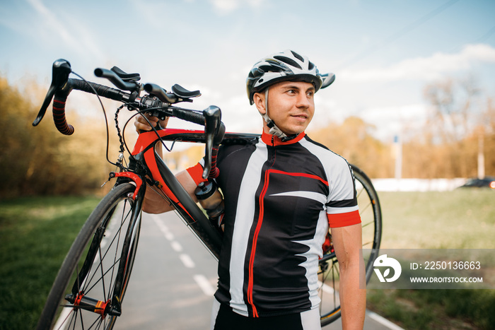 Bycyclist keeps the bike on shoulder after biking