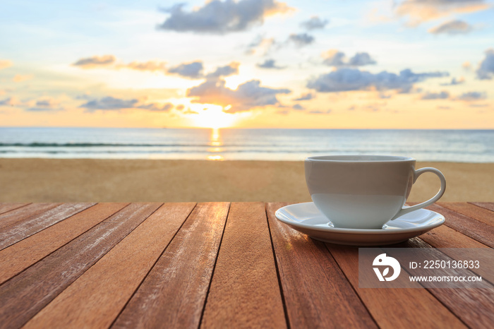 木桌上的白咖啡杯，日落或日出的景色