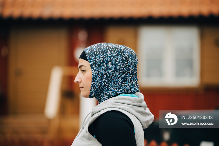 Side view of mature woman wearing hijab and sportswear during routine training