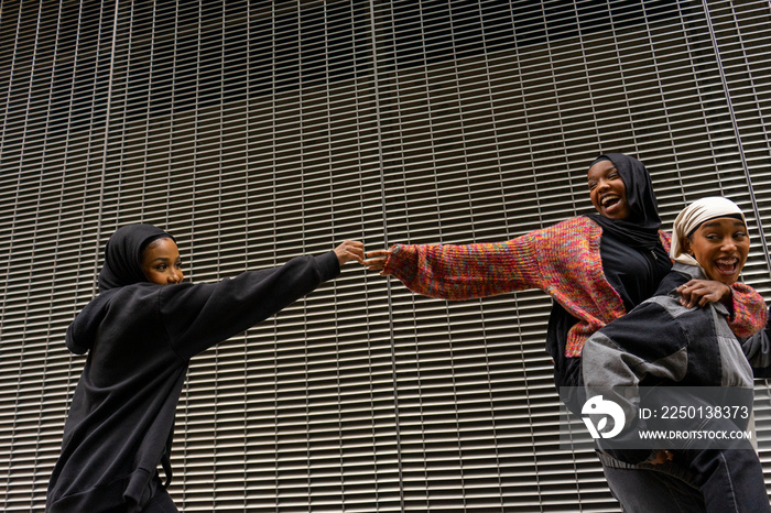 Smiling young women wearing�hijabs�walking in city