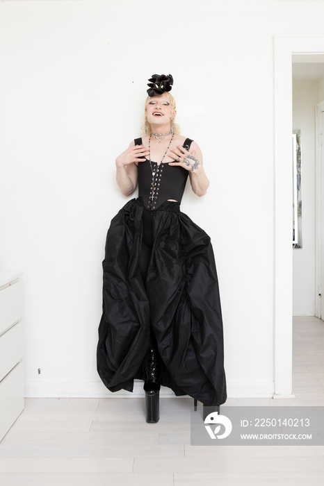 non-binary hispanic person wearing black corset dress holding flowers