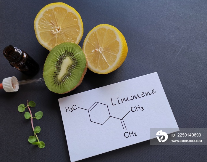 Structural chemical formula of limonene with fresh citrus fruit and a glass bottle of essential arom