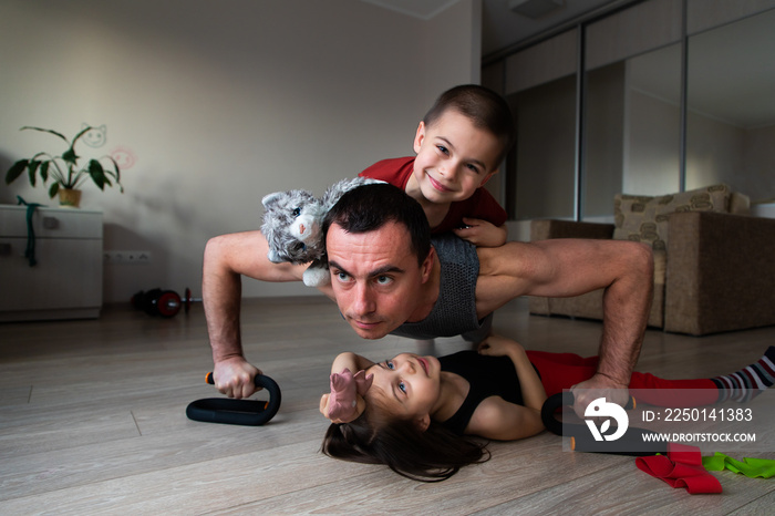 Father doing workout and funny children having fun and playing with him