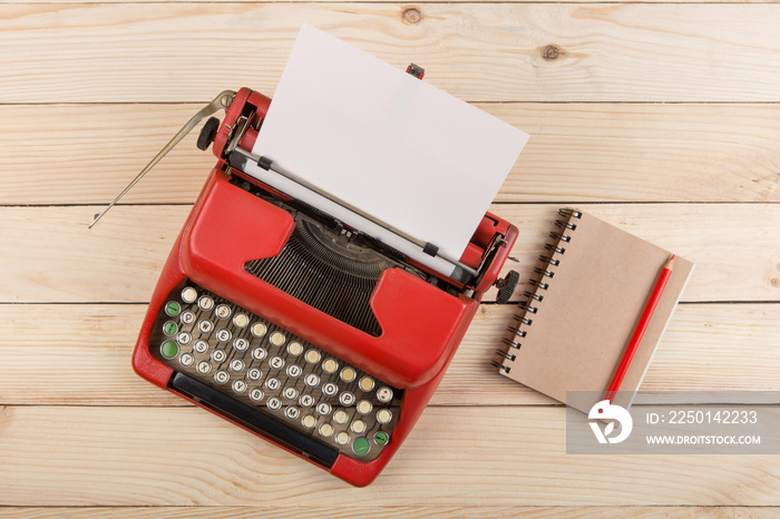 Writer or journalist workplace - vintage red typewriter on the wooden desk