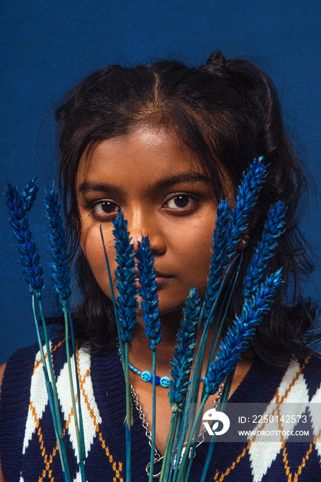 portrait of dark skinned Indian woman from Malaysia against dark blue background