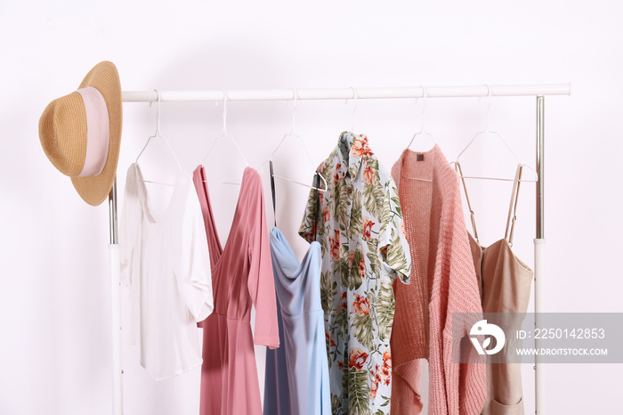 Womens hip clothing store interior concept. Row of different colorful female clothes hanging on rac