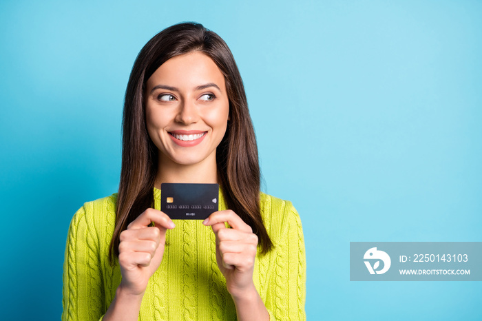 Photo of young girl happy positive smile hold bank card look empty space isolated over blue color ba