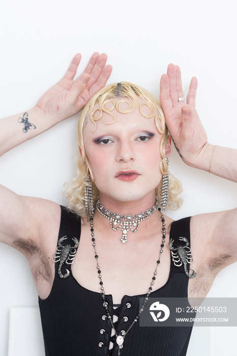 close up beauty of non-binary person wearing black dress and holding cflowers