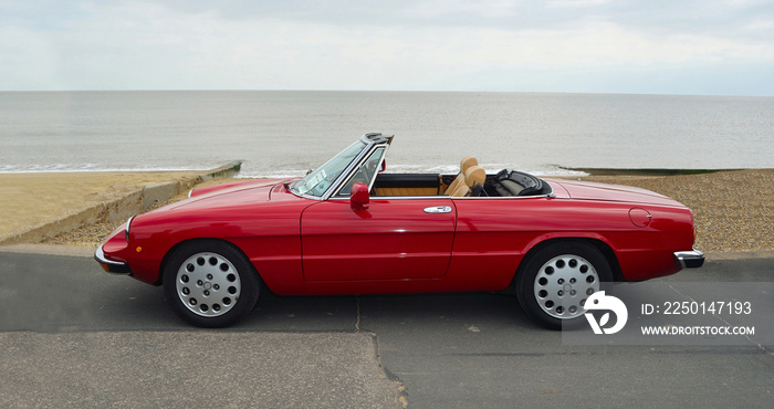 Classic Red Italian Sports  Convertible  Motor Car Parked on Seafront Promenade.